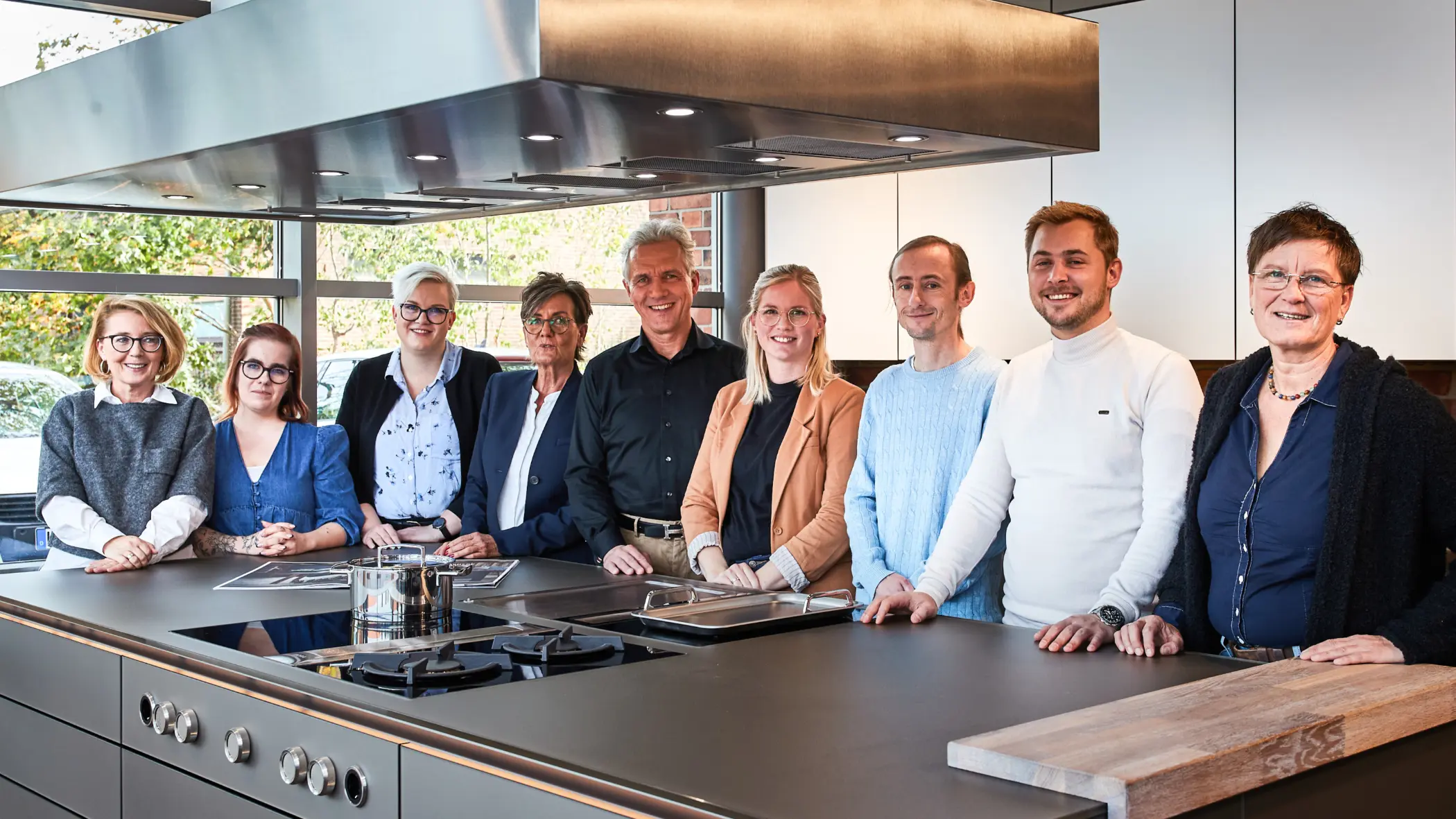 Gruppenbild des Rosenowski-Teams in Thönse vor einer Kücheninsel